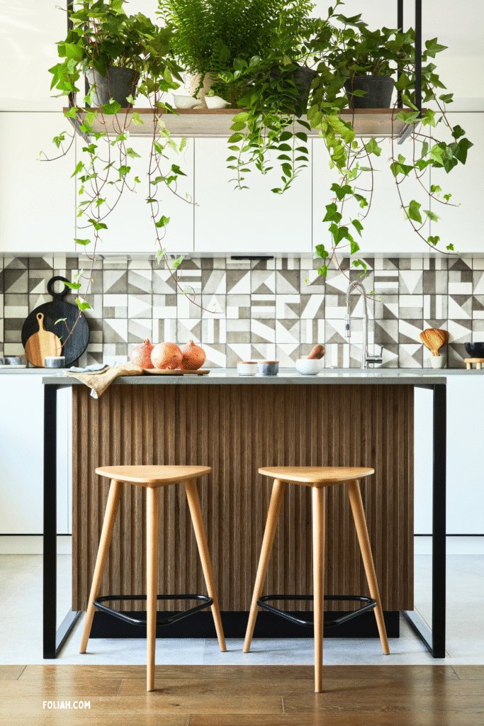 13 Gorgeous Kitchen Plant Styling Ideas You’ll Want to Copy 2 at Foliah Stylish kitchen interior design with dining space. Workspace with kitchen accessories on the back ground. Creative walls. Minimalistic style an plant love concept.