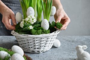 DIY Easter table centerpiece with festive eggs, moss and bunny. Spring composition