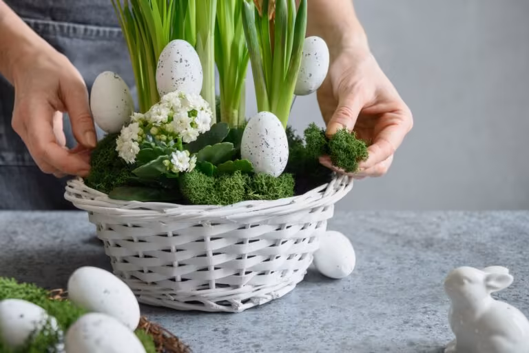 DIY Easter table centerpiece with festive eggs, moss and bunny. Spring composition