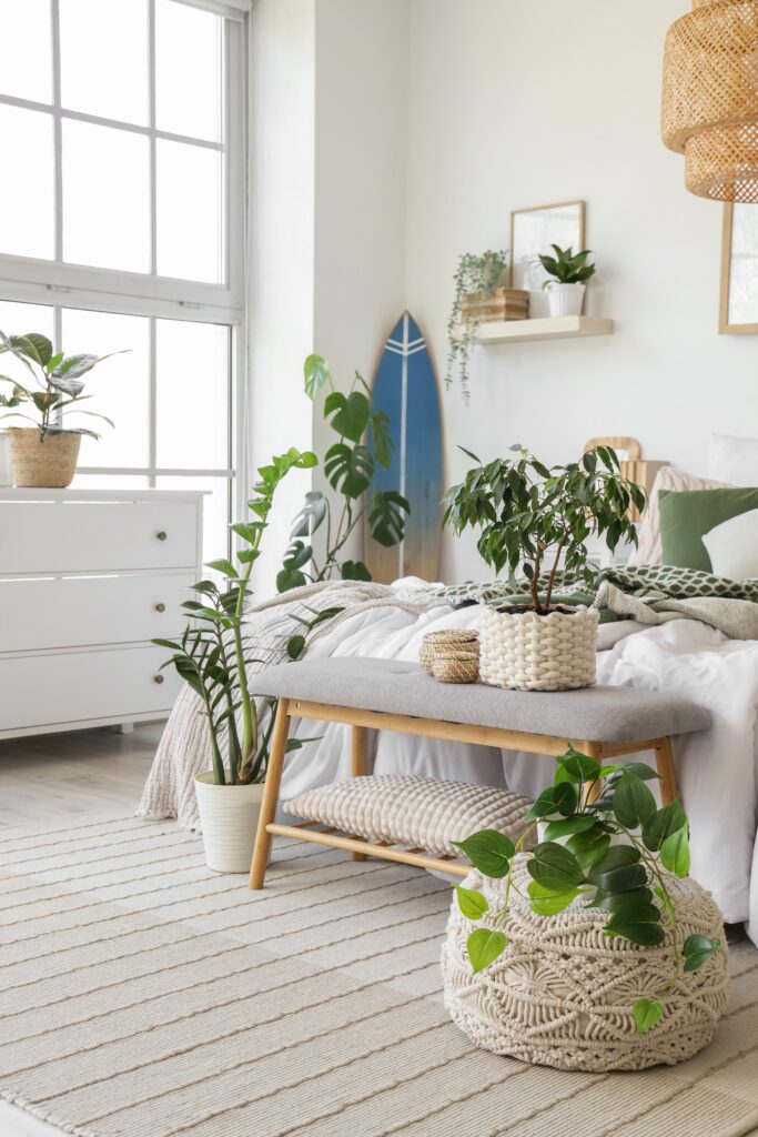 Bedroom with plants styled around a bench at the end of the bed, including floor plants and potted greenery for a balanced layout.