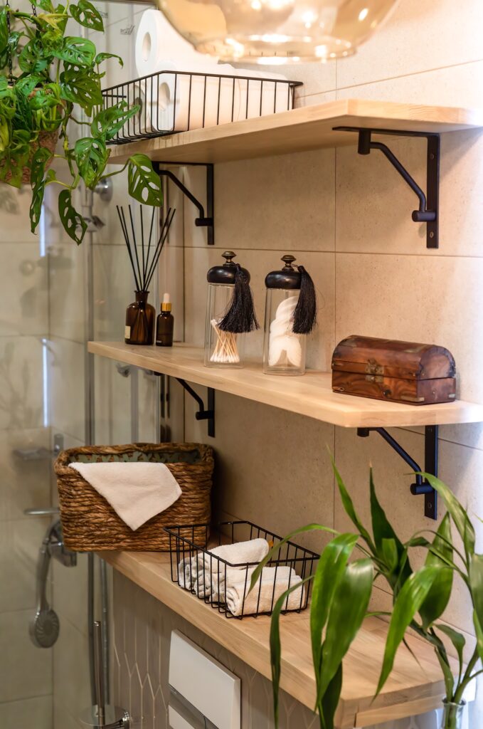 Minimal boho style of bathroom interior with wooden shelves and indoor hanging plants inc Monstera