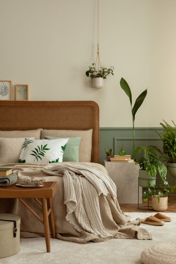 Bedroom with plants styled around the bed, including a hanging plant, tall floor plant, and smaller potted plants near the nightstand for a calm and balanced look.