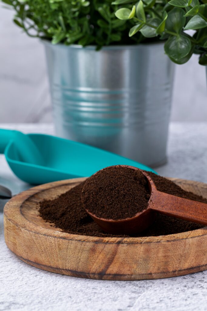 Zero waste - wooden bowl in front of pots and trowel, with a spoon and Coffee capsules and coffee grounds kkeokki